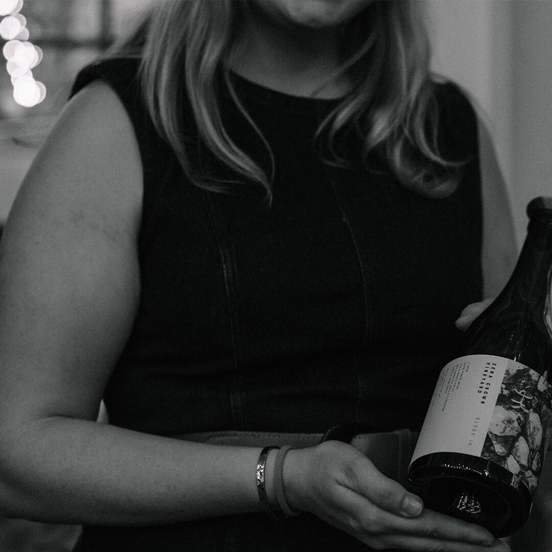 Woman holding a bottle of Zena Crown Pinot Noir